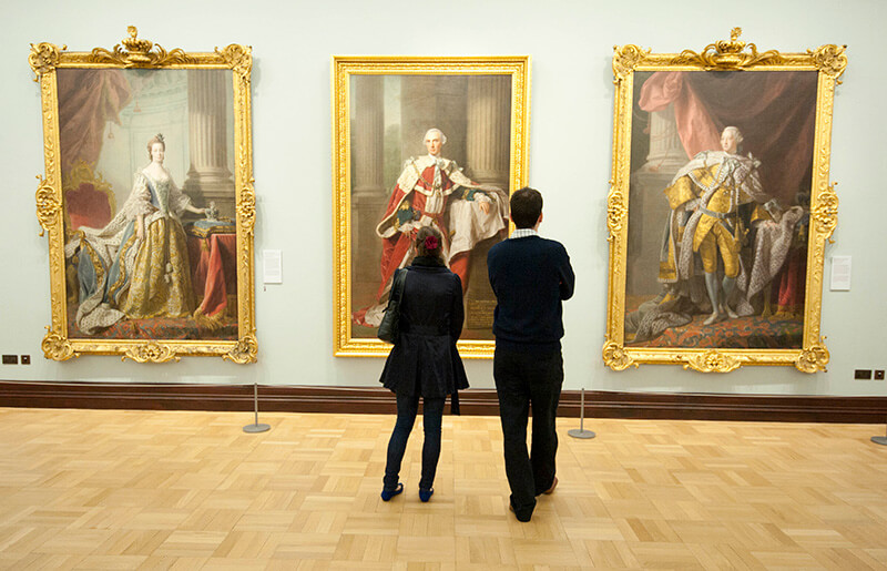 Two visitors looking at paintings at The National Gallery of Scotland